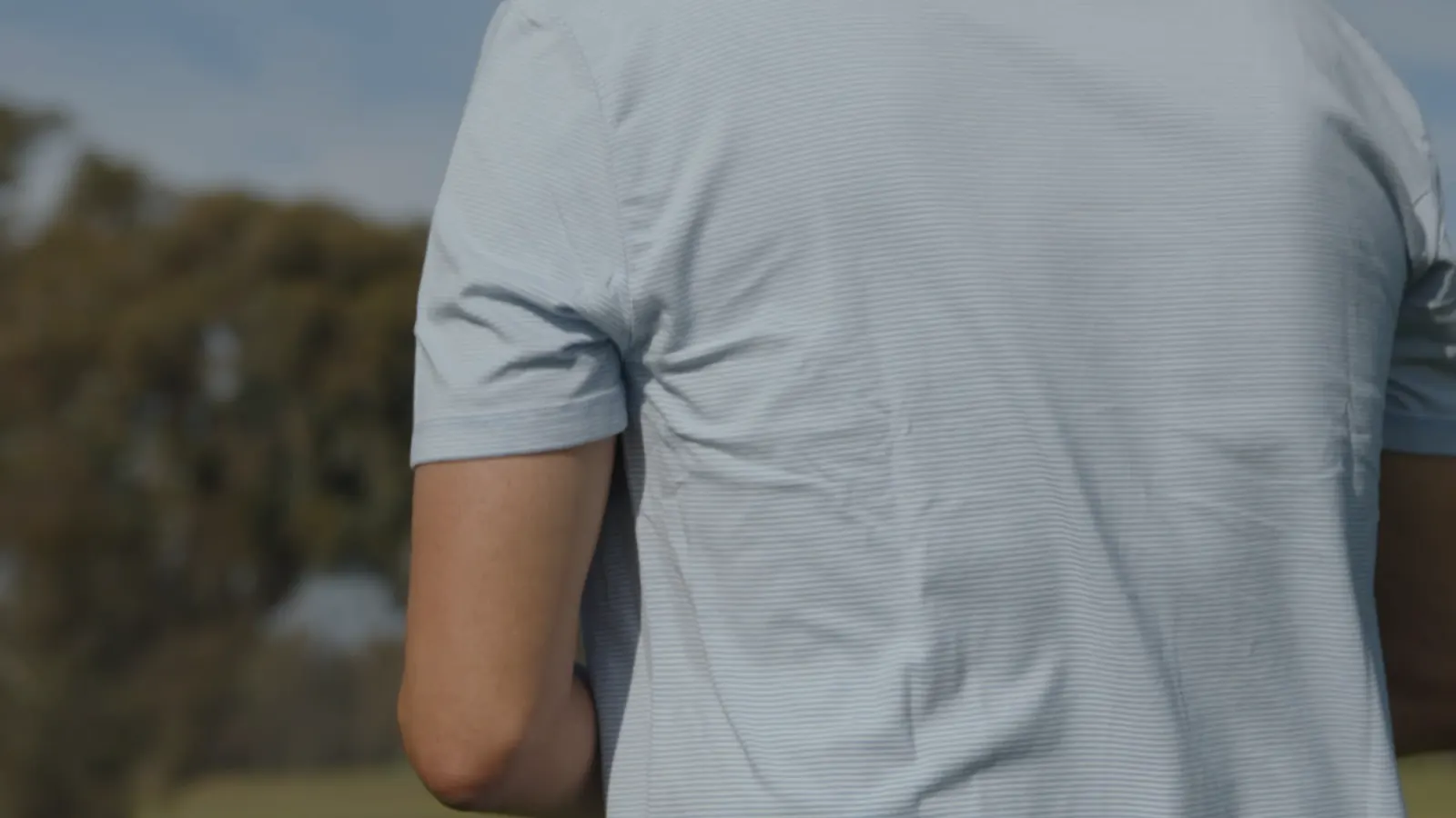 The back of a blue HyperNatural tee, outdoors.