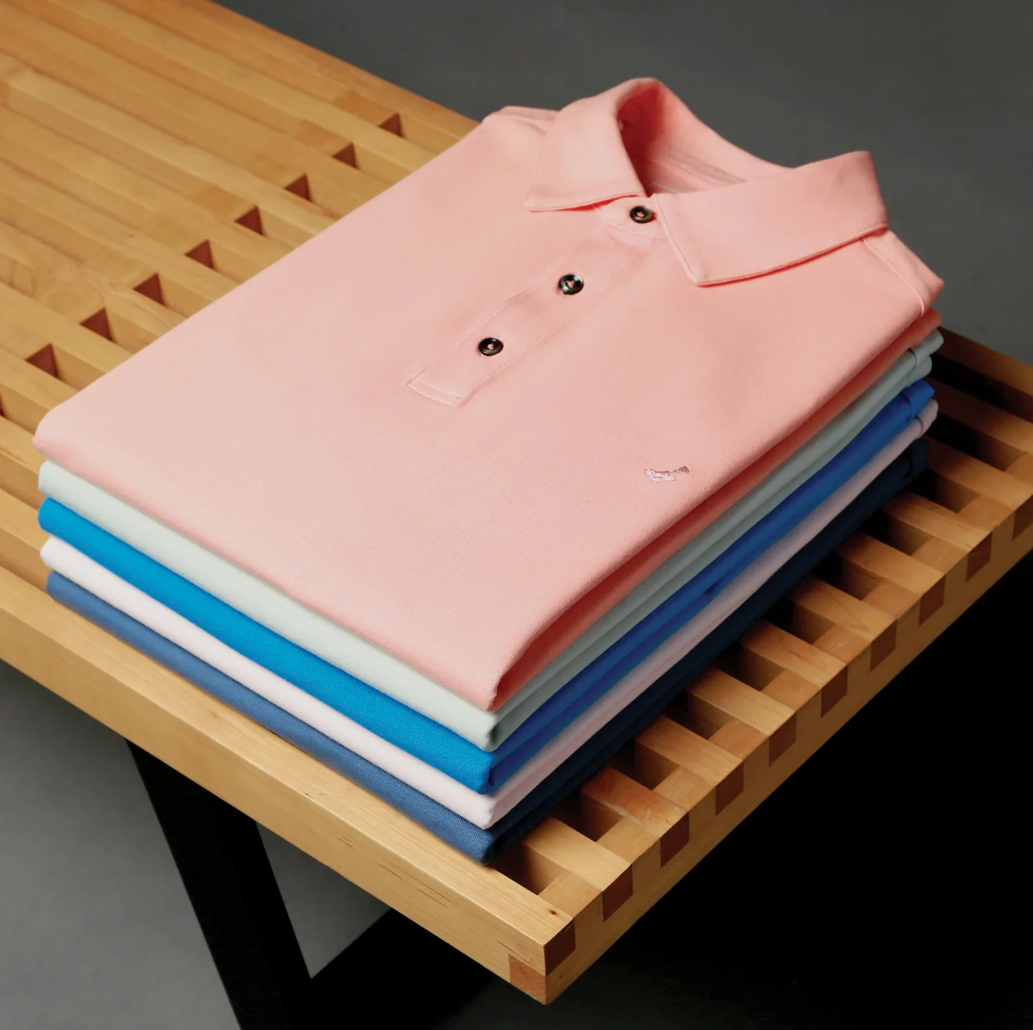 Folded polos on wooden slats.